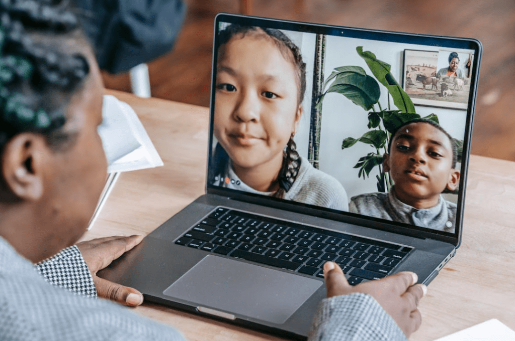 Vrouw videobelt met kinderen technologie in het onderwijs| Bron: Pexels: Katerina Holmes