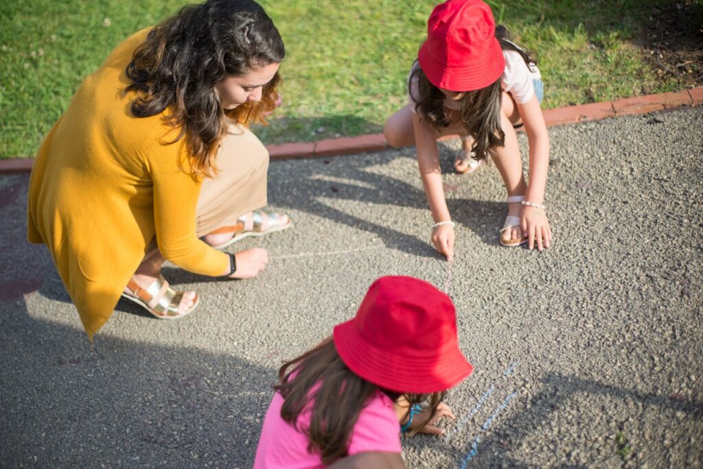 Kinderen die met een pedagogisch medewerkster met een flexibele baan in de kinderopvang aan het buiten spelen zijn.