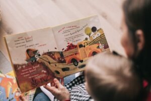 Kind en pedagogisch medewerker die een boek aan het lezen zijn in de kinderopvang