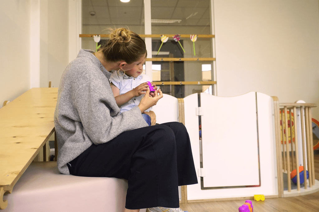 Pedagogisch medewerker met kind op schoot