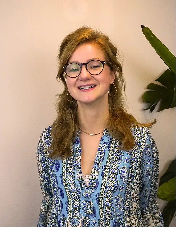 Glimlachende StudyWorker met bril en blauwe blouse