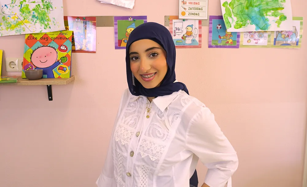 Lachende StudyWorker met hoofddoek in een kinderdagverblijf